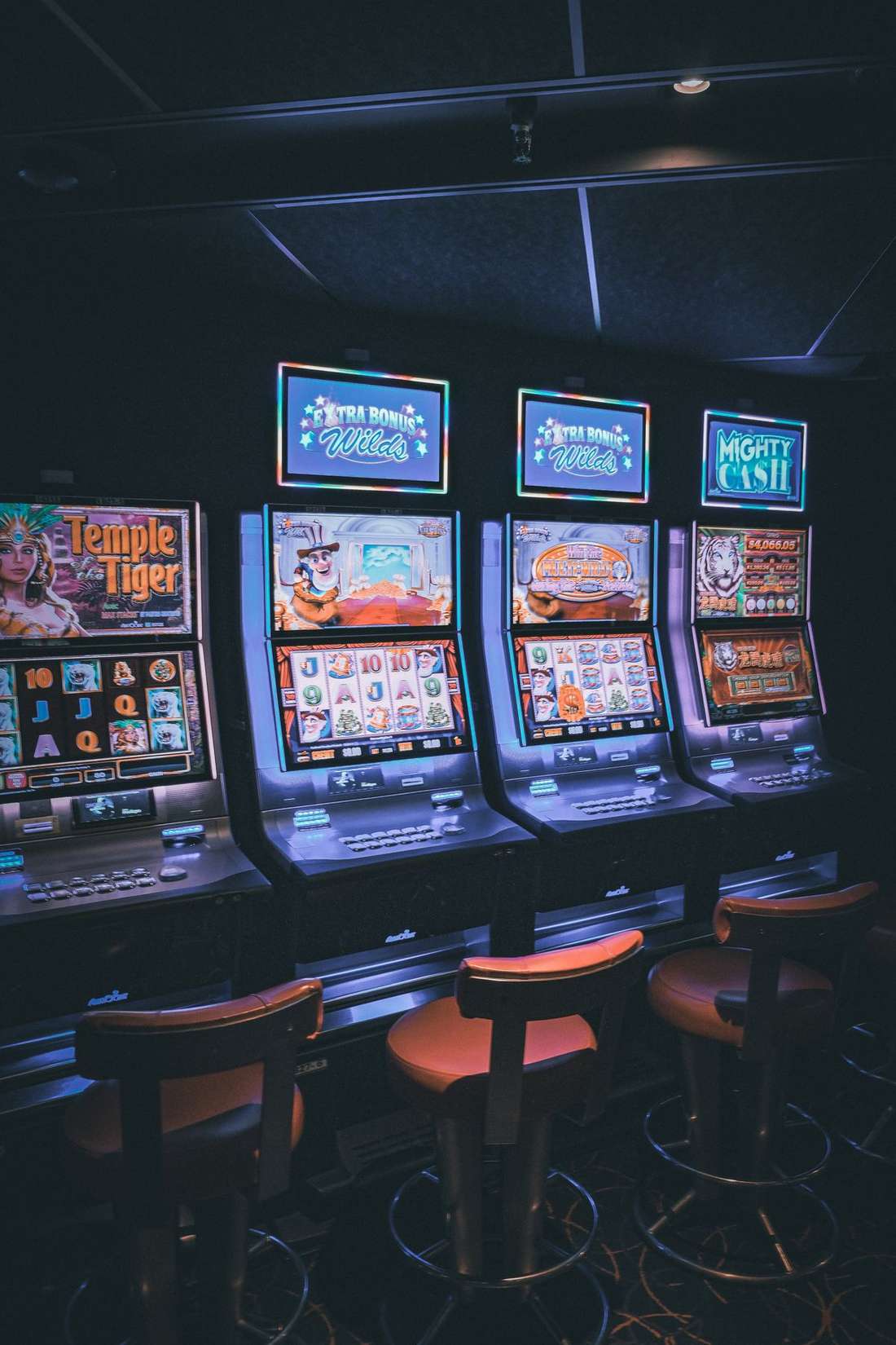 Barisan mesin slot menyala di ruangan gelap